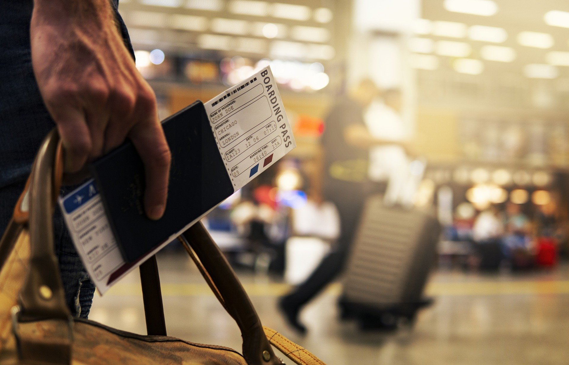 Un billet d'avion dans la main d'un passager, déposé à l'aéroport par un chauffeur vtc.